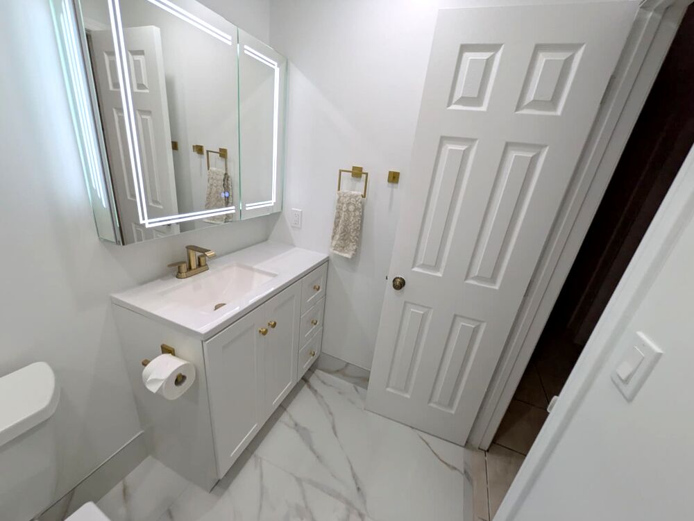 Completed Kendall bathroom with white vanity and brushed gold finishes