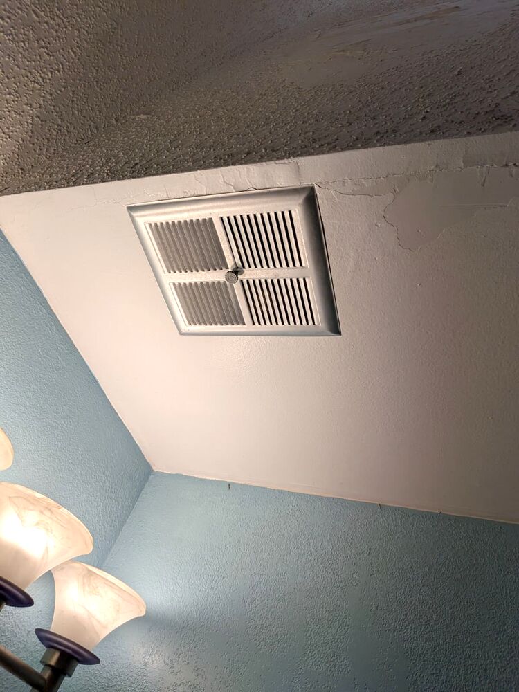 Ceiling vent with peeling paint and cracking along the edge
